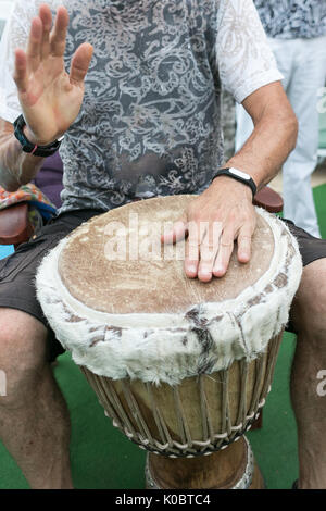 Drum-, Percussion Instrumente und Kultur Konzept - closeup auf Händen der Musiker spielen mit traditionellen afrikanischen Djembe, Sommer draußen Konzert, selektiver Fokus, senkrecht. Stockfoto