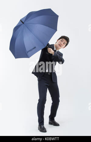 Geschäftsmann mit Regenschirm ständigen Suchen nach finsteres Gesicht Stockfoto