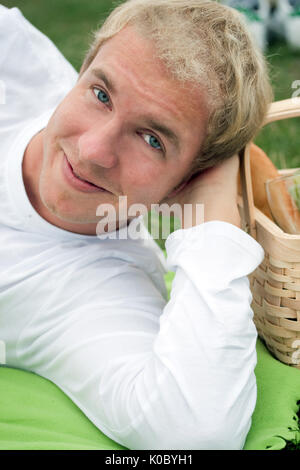 Junger Mann liegend auf Picknick Einstellung Stockfoto