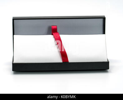 Bleistift, Kugelschreiber Geschenk Box mit Band, rotes Tuch in der Mitte der Box auf weißem Hintergrund Stockfoto