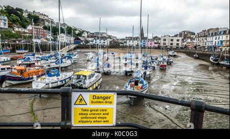 Gefahr plötzlichen Druckabfall Warnschild am Hafen von Ilfracombe, mit vielen angelegten Boote bei Ebbe, und Eigenschaften mit Blick auf. Küste von North Devon, England, UK. Stockfoto