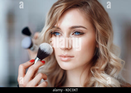 Prozess der Anwendung von Make-up im Gesicht des Mädchens, close-up Stockfoto