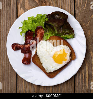 Rührei mit herzförmigen Wurst, Ansicht von oben Stockfoto