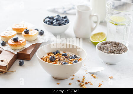 Müsli mit Joghurt und mini Käsekuchen mit Heidelbeeren zum Frühstück. Stockfoto