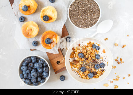 Müsli mit Joghurt und mini Käsekuchen mit Heidelbeeren zum Frühstück. Stockfoto