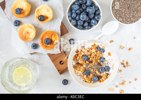 Müsli mit Joghurt und mini Käsekuchen mit Heidelbeeren zum Frühstück. Stockfoto