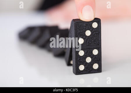 Zugeschnittenes Bild der Hand Frau spielen Domino auf Tisch Stockfoto