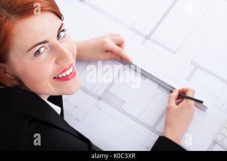 Hohen winkel Portrait der Unternehmerin arbeiten an Blueprint im Büro Stockfoto
