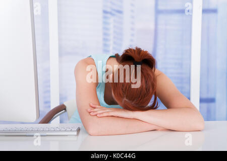 Müde junge Geschäftsfrau, schlafen in der Computer-Schreibtisch im Büro Stockfoto