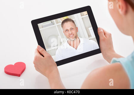 Zugeschnittenes Bild der jungen Frau mit Video mit Freund auf digitalen tablet Chat Stockfoto