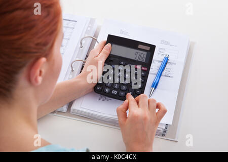 Hohen winkel Porträt der schönen jungen Frau Berechnung Rechnung am Schreibtisch Stockfoto