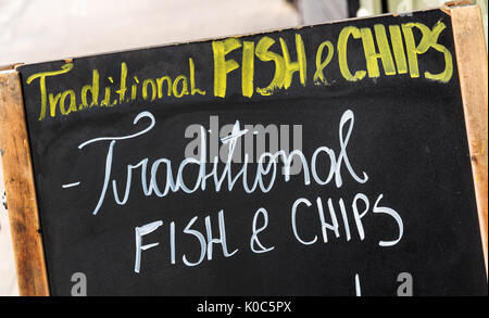 In der Nähe auf einem Fisch und Chips Zeichen, Text traditionellen Fish und Chips auf einer Tafel in der Straße geschrieben Stockfoto