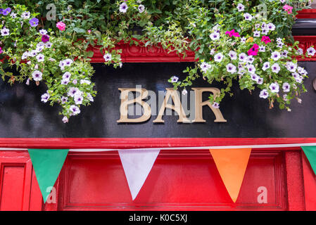 Bar Schild mit Blumen und Farben der irischen Flagge, Irish Pub in Dublin, Irland Stockfoto