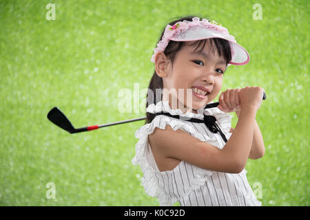 Asiatische chinesische Mädchen spielen Golf auf dem grünen Rasen Stockfoto