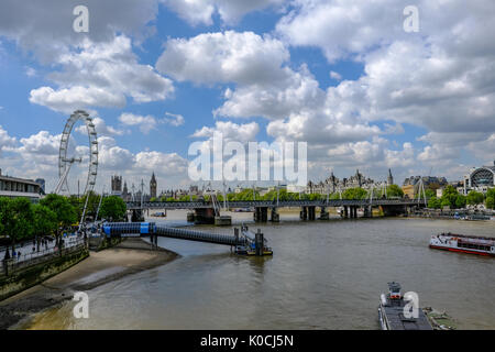 London, Großbritannien - 2. Mai 2017: Festival Pier mit Millennium Wheel und Hungerford Brücke. Schön bewölkt und blauer Himmel mit Fluss Boote. Stockfoto