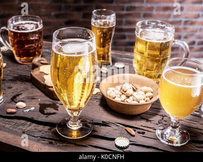 Gläser Bier und Snacks auf dem Holztisch. Stockfoto