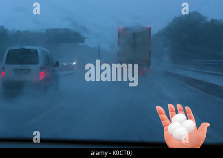 Machen Sie einen Spaziergang mit schweren Hagel, Schnee und Regen auf der Autobahn. Menschliche Hand mit großen Hagel. Konzept Sturm armen Fahrbedingungen. Stockfoto