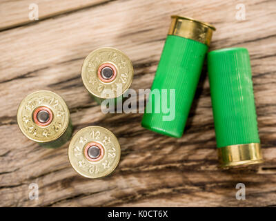 12 guage Patrone für Pumpe Schrotflinte auf dem Holztisch. Stockfoto