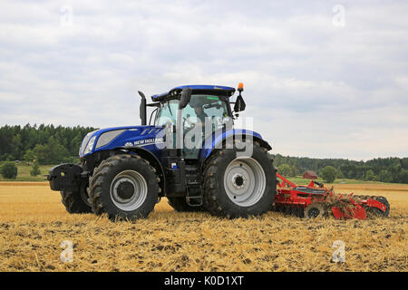 SALO, Finnland - 18. AUGUST 2017: Landwirt pflegt Feld mit New Holland T 7.225 AC Traktor und Kverneland Qualidisc Bauer 3500 Scheibenegge auf Puonti Stockfoto