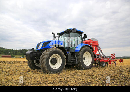 SALO, Finnland - 18. AUGUST 2017: Landwirt pflegt Feld mit New Holland T6 Traktoren und Kverneland TS-Bohrer auf Puontin Peltopaivat 2017 Stockfoto