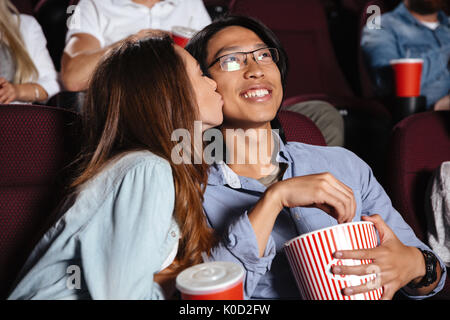 Image der jungen Liebenden paar sitzen im Kino film ansehen und küssen Stockfoto