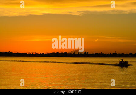 Sonnenuntergang mit der Silhouette von einem Boot auf der Inter Coastal in Belleair Bluffs, Florida Stockfoto