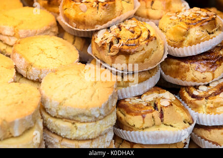 Frisch gebackenes Gebäck in einer Bäckerei übereinander in einem Shop Anzeige in einem full frame Nahaufnahme gestapelt Stockfoto