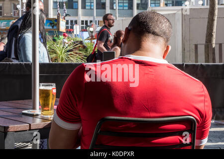 Mann sitzt und trinkt Bier außerhalb in einer Innenstadt, Nottingham, England, Großbritannien Stockfoto