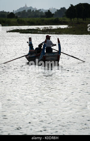 Ein traditionelles Boot der sunsest am Taungthaman Lake, Mandalay, Myanmar anzeigen Stockfoto