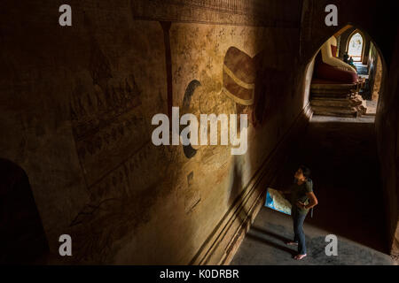 Frau sieht die Wand Friese in der Sulamani Guphaya Tempel in das Weltkulturerbe von Bagan, Myanmar Stockfoto