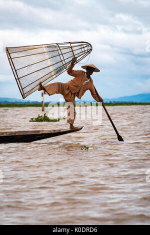 Fischer mit einem traditonellen Federball Stil Fischernetz, Inle Lake, Myanmar Stockfoto