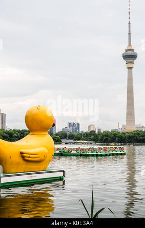 Eine riesige gelbe Ente schwimmend auf Yu Yuan Tan See in Peking, China, Rückblick auf die CCTV-Towner. Stockfoto