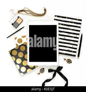 Flach Mode feminin home office Arbeitsbereich mit Tablet, elegantes schwarzes Gold Notebooks, Kosmetik und Schmuck auf weißem Hintergrund. Ansicht von oben auf die Frauen Business Schreibtisch Stockfoto