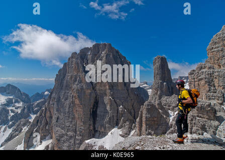 Brenta, Trentino, Italien. Kletterer auf der Via ferrata delle Bocchette Centrali entiero'. Im Hintergrund die Cima Brenta Alta und der berühmten campani Stockfoto