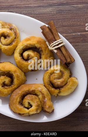 Top down Sicht auf Zimtschnecken, traditionelle hausgemachte Kuchen, serviert auf dem ovalen Schild Stockfoto