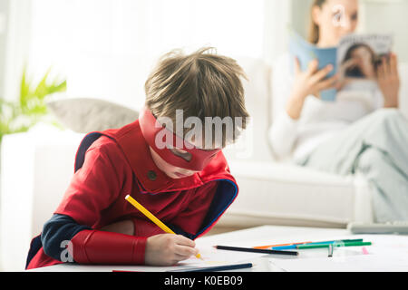 Niedliche Superhelden junge mit Mutter lesen auf Hintergrund gezeichnet. Stockfoto