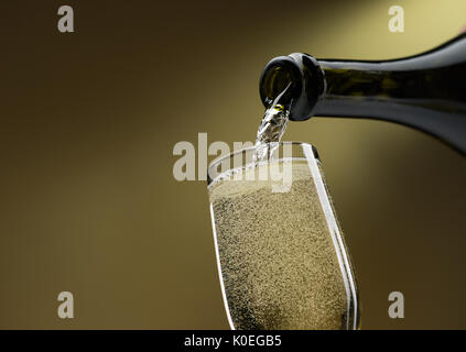 Gießen Weißwein aus einer Flasche in ein Weinglas: Feier und Weinprobe Stockfoto