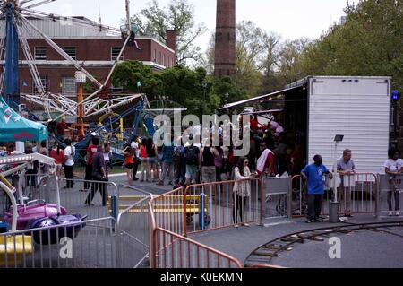 Eine Menschenmenge onlooking und in der Schlange für verschiedene Antenne Karneval Fahrten hinter der Milton S. Eisenhower Bibliothek für Spring Fair, ein Student-run Spring Carnival, an der Johns Hopkins University, Baltimore, Maryland, April, 2015. Mit freundlicher Genehmigung von Eric Chen. Stockfoto