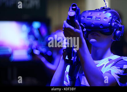 Köln, Deutschland. 23 Aug, 2017. Die Besucher der Gamescom spielen auf dem Computer spiel Hologate mit einem VR (Virtuelle Realität) Headset in Köln, Deutschland, 23. August 2017. Der computer spiele Messe Gamescom Ort zwischen dem 22. und dem 26. August 2017 stattfindet. Foto: Oliver Berg/dpa/Alamy leben Nachrichten Stockfoto