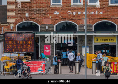 London, Großbritannien. 23 August, 2017. Personal und Schilder warnen die Fahrgäste über eine 75%ige Reduzierung der Service durch Clapham Junction gehen auf den Donnerstag 24. und Freitag, den 25. August. Dies wird im Rahmen der laufenden Unterbrechungen für Pendler im August aufgrund der Waterloo Plattform upgrade arbeiten werden. London, 23. Aug 2017. Credit: Guy Bell/Alamy leben Nachrichten Stockfoto