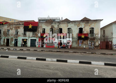 Luanda, Angola. 23 August, 2017. Die Bewohner sitzen Sie am Wahltag in Angola unter der Fahnen der regierenden Volksbewegung für die Befreiung Angolas (MPLA) Partei und Poster anzeigen canidate Präsidenten Joao Lourenco. Credit: Wird Reynolds Fotografie/Alamy leben Nachrichten Stockfoto