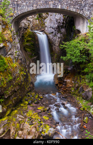 Christine fällt durch die Trümmer Steinbogenbrücke der Paradise Road, Mount Rainier National Park, Cascade Range, Washington, USA umrahmt. Stockfoto