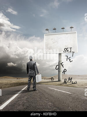 Ein Mann stehen und starrte auf eine leere Reklametafeln mit fallenden Buchstaben. Stockfoto