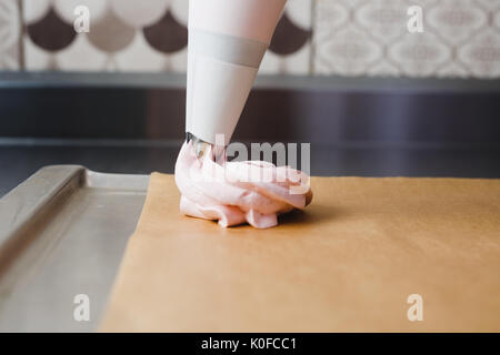 Extrusion Der eibisch Masse aus der kulinarischen Tasche auf dem Backblech Stockfoto