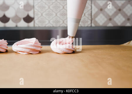 Extrusion Der eibisch Masse aus der kulinarischen Tasche auf dem Backblech Stockfoto