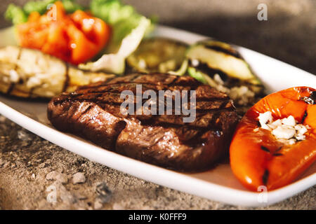 Lecker gegrilltes Rindersteak mit gegrilltem Gemüse auf einer Seite Stockfoto