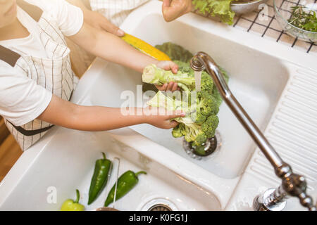 Vater mit kleinen Sohn wäscht Gemüse in der Küche vor dem Essen Stockfoto