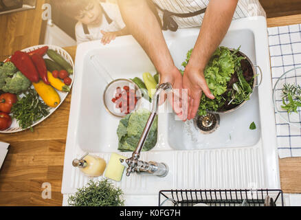 Vater mit kleinen Sohn wäscht Gemüse in der Küche vor dem Essen Stockfoto