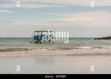 Ein Meer der Traktor transportiert Besucher zurück von Burgh Island zu Bigbury on Sea, Devon, Großbritannien. Stockfoto