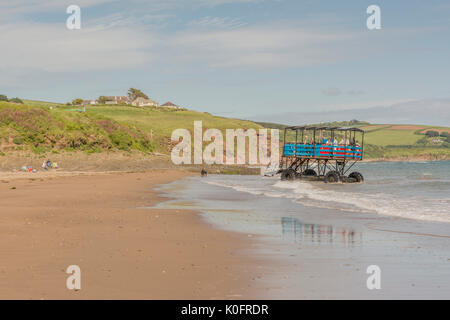 Ein Meer der Traktor transportiert Besucher zurück von Burgh Island zu Bigbury on Sea, Devon, Großbritannien. Stockfoto